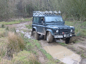 Land Rover Defender driving though mud