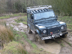 Land Rover Defender driving though mud