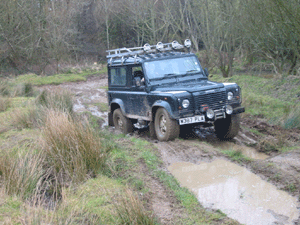 Land Rover Defender driving though mud