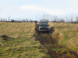 Land Rover Defender driving down a hill